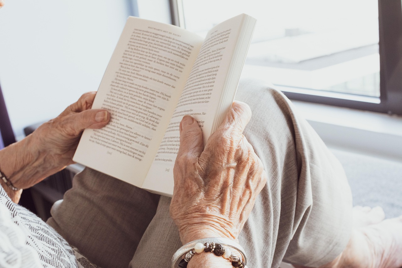 older adult holding an open book